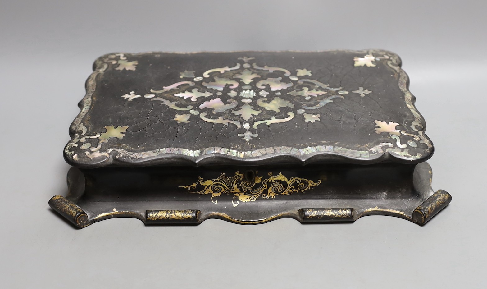 A Victorian papier-mâché games box with mother of pearl inlay and mother-of-pearl counters